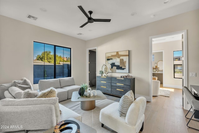 living room with ceiling fan and light hardwood / wood-style flooring