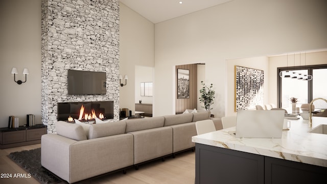 living room featuring a fireplace, high vaulted ceiling, light hardwood / wood-style floors, and sink