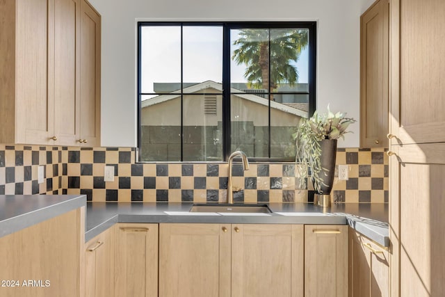 kitchen featuring light brown cabinetry, tasteful backsplash, and sink