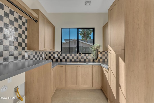 kitchen with decorative backsplash, light brown cabinetry, and sink