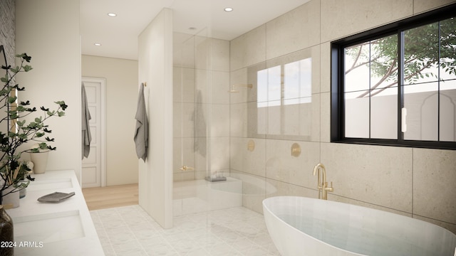 bathroom with wood-type flooring, vanity, tile walls, and a tub