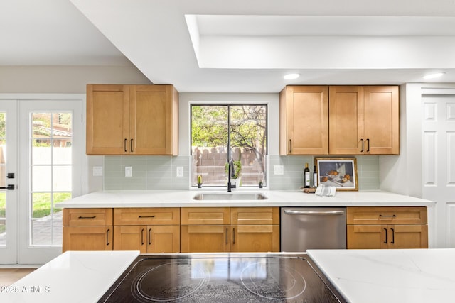 kitchen featuring stainless steel dishwasher, decorative backsplash, a wealth of natural light, and a sink