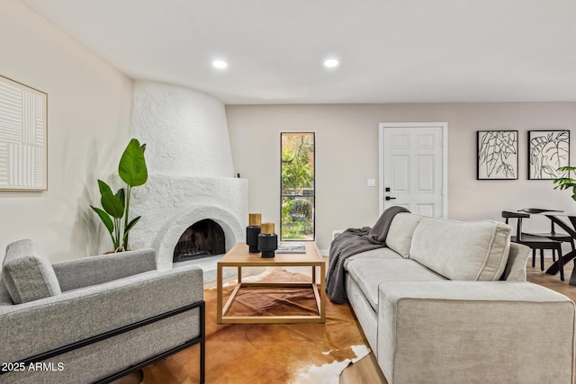 living room featuring a large fireplace, wood finished floors, and recessed lighting