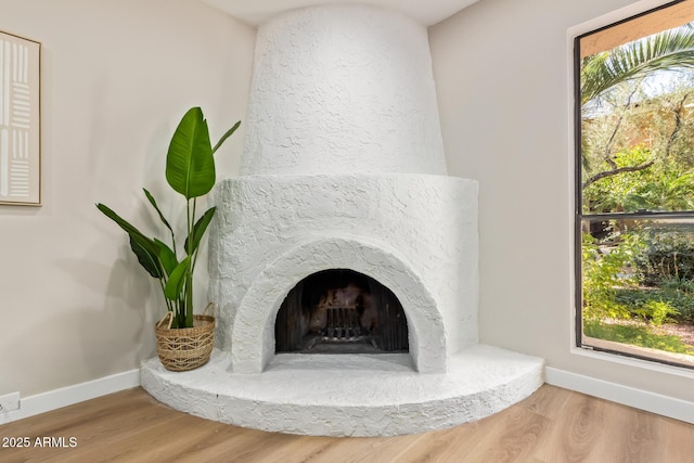 details featuring a premium fireplace, baseboards, and wood finished floors