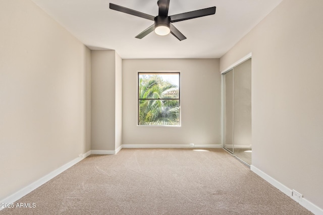 empty room featuring carpet floors, baseboards, and a ceiling fan