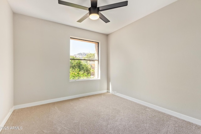 spare room with carpet floors, ceiling fan, and baseboards