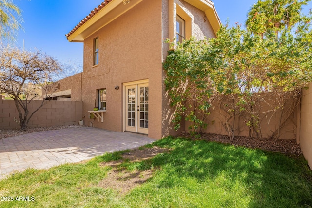 back of house featuring a patio, french doors, a fenced backyard, and stucco siding