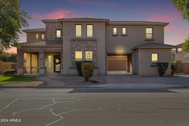 mediterranean / spanish home featuring covered porch and a garage