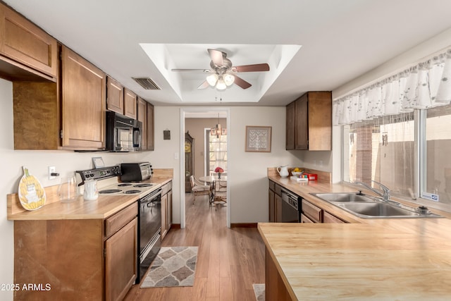 4024 W Griswold Rd, Phoenix, AZ 85051 - kitchen featuring black appliances, a sink, a raised ceiling, light wood finished floors, and a ceiling fan