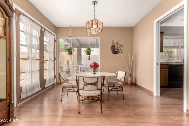 4024 W Griswold Rd, Phoenix, AZ 85051 - dining space with wood finished floors, a chandelier, a textured ceiling, baseboards, and french doors