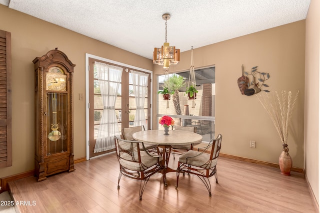 4024 W Griswold Rd, Phoenix, AZ 85051 - dining room featuring a chandelier, light wood-style floors, baseboards, a textured ceiling, and french doors