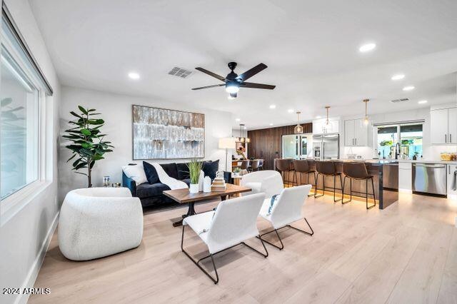 living room with light wood-type flooring and ceiling fan