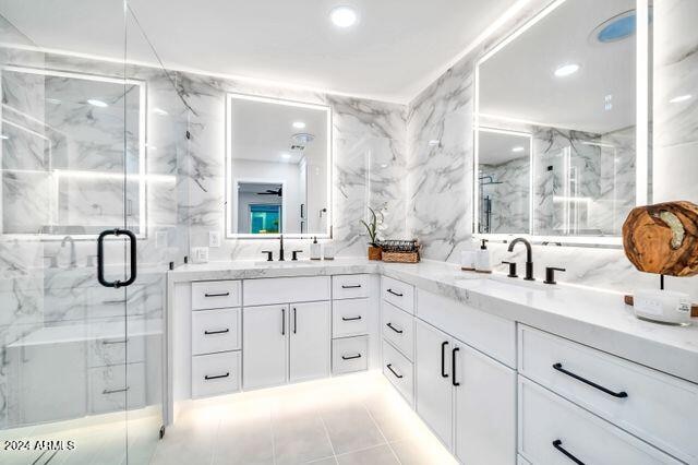 bathroom with tile walls, vanity, and a shower with shower door