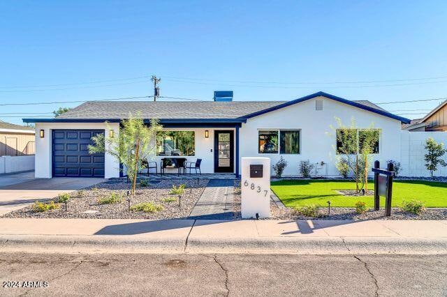 ranch-style home featuring a garage and a front lawn