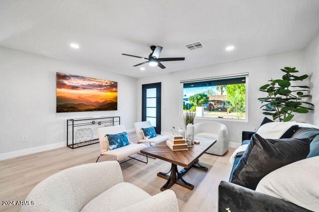 living room with ceiling fan and light hardwood / wood-style flooring