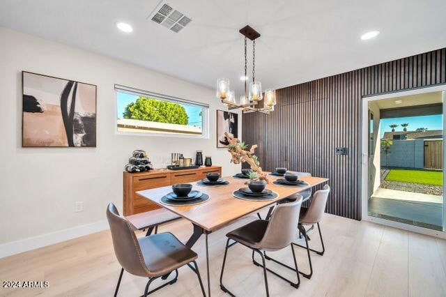 dining room with a notable chandelier and light wood-type flooring