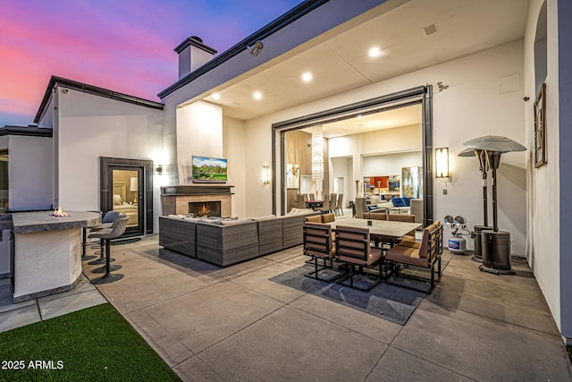 5404 N 41st St, Phoenix, AZ 85018 - patio terrace at dusk with an outdoor living space with a fireplace, a patio, and outdoor dining area