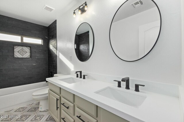 full bathroom featuring vanity, tiled shower / bath combo, and toilet