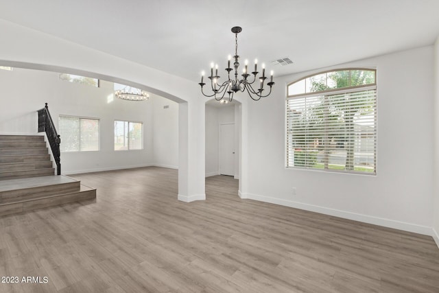 interior space featuring hardwood / wood-style floors, a wealth of natural light, and an inviting chandelier