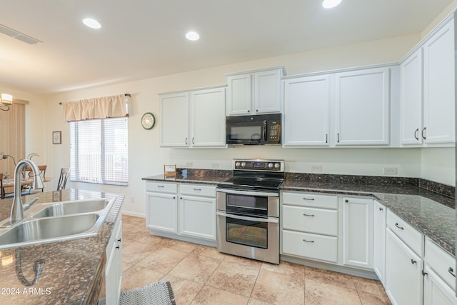 kitchen featuring stainless steel range with electric stovetop, white cabinets, and sink