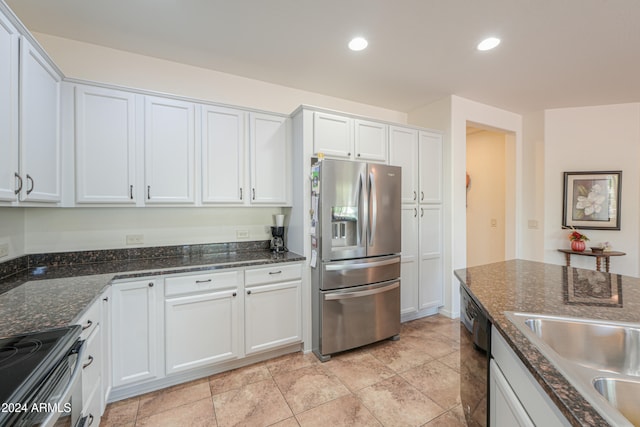 kitchen with white cabinetry, dark stone countertops, appliances with stainless steel finishes, and light tile patterned floors