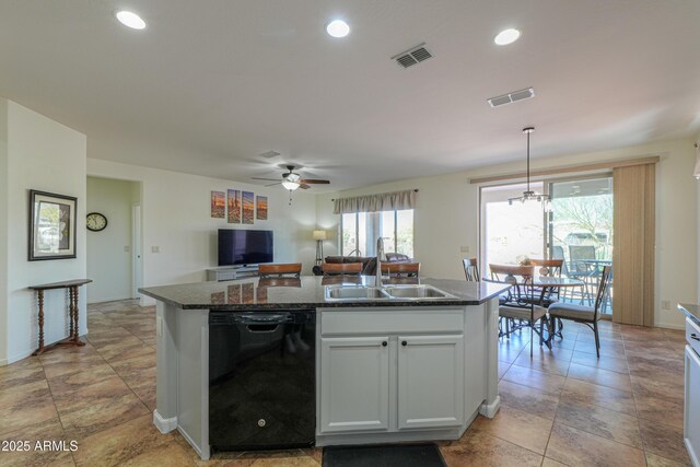 kitchen featuring black dishwasher, visible vents, an island with sink, and a sink