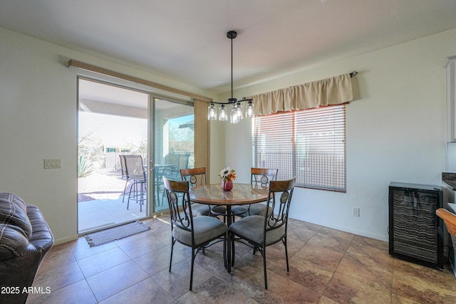 dining area with an inviting chandelier, plenty of natural light, and baseboards