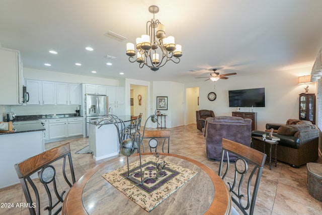 dining space with ceiling fan with notable chandelier