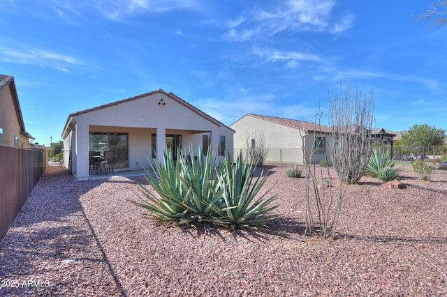 back of property with stucco siding, a patio area, and a fenced backyard