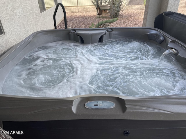 details with a jacuzzi and fence