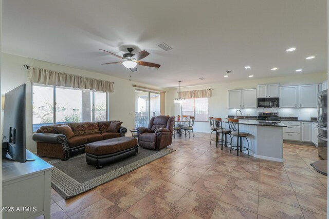 living room featuring ceiling fan, recessed lighting, and visible vents