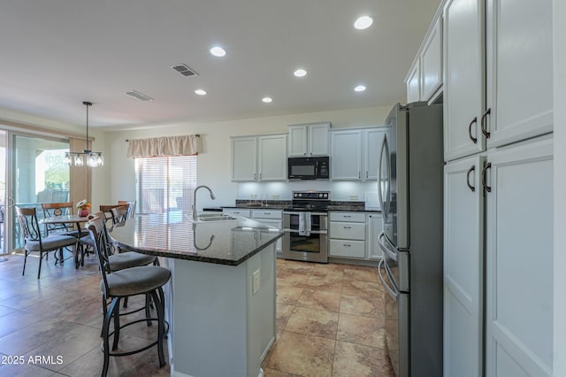 kitchen featuring a breakfast bar, visible vents, stainless steel appliances, and a sink