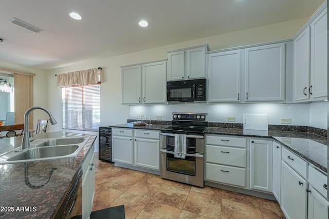 kitchen featuring recessed lighting, dark stone counters, black appliances, a sink, and visible vents