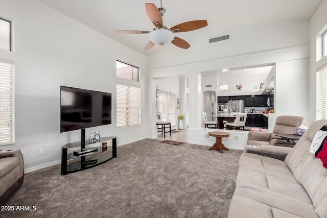 living area featuring baseboards, ceiling fan, visible vents, and carpet