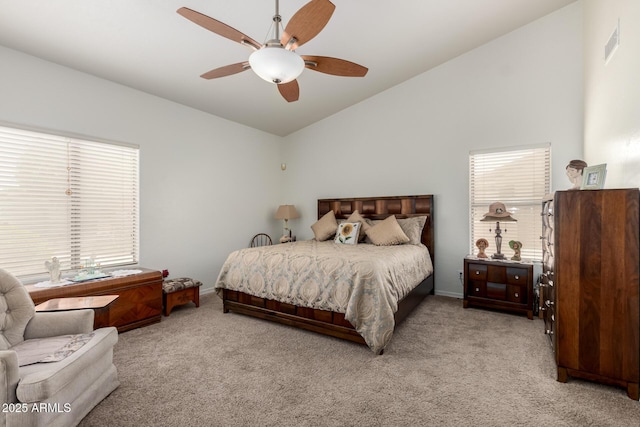 carpeted bedroom featuring multiple windows, lofted ceiling, visible vents, and a ceiling fan