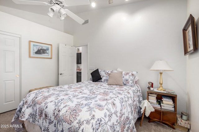 carpeted bedroom featuring visible vents, a ceiling fan, and vaulted ceiling