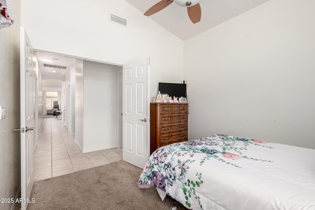 bedroom with light tile patterned flooring, light carpet, vaulted ceiling, and visible vents