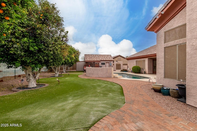view of yard featuring a patio, a fenced in pool, a fenced backyard, and an outdoor structure