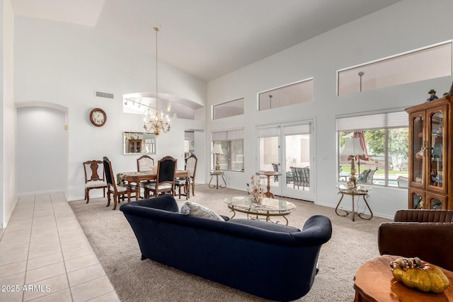 living room featuring high vaulted ceiling, visible vents, a chandelier, light tile patterned floors, and light colored carpet