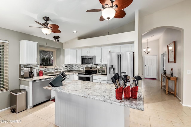 kitchen featuring light stone counters, backsplash, white cabinets, and appliances with stainless steel finishes