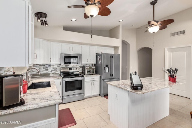 kitchen featuring a kitchen island, white cabinetry, appliances with stainless steel finishes, and sink