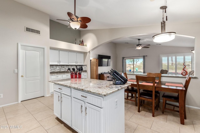 kitchen featuring white cabinetry, tasteful backsplash, vaulted ceiling, hanging light fixtures, and a kitchen island