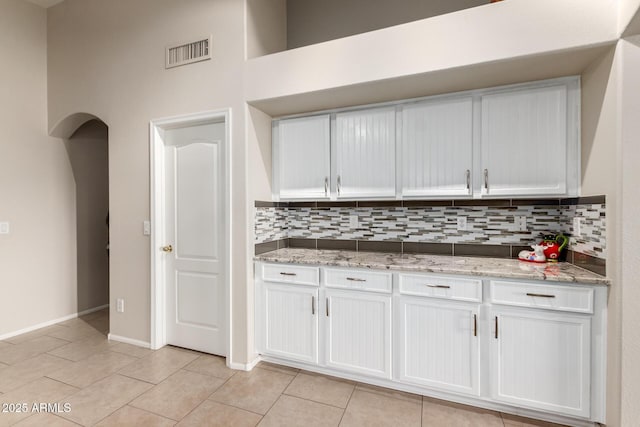 kitchen with white cabinetry, decorative backsplash, and light tile patterned floors