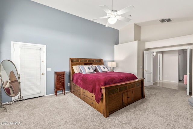 carpeted bedroom with ceiling fan and high vaulted ceiling