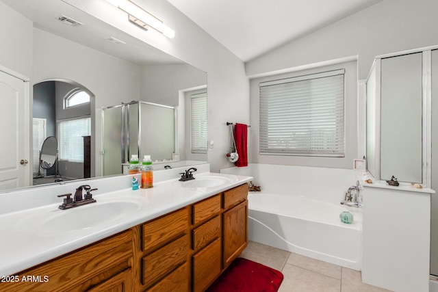 bathroom with tile patterned flooring, shower with separate bathtub, lofted ceiling, and vanity