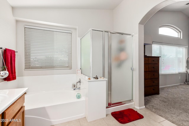 bathroom featuring vanity, vaulted ceiling, tile patterned floors, and shower with separate bathtub