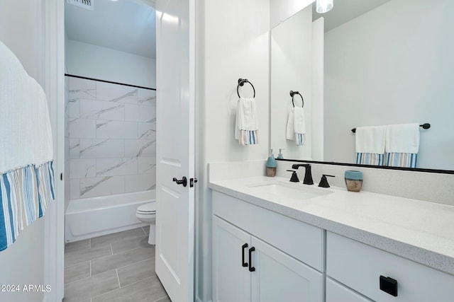 full bathroom featuring vanity, tiled shower / bath, and toilet