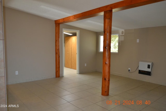 tiled empty room featuring vaulted ceiling with beams and heating unit