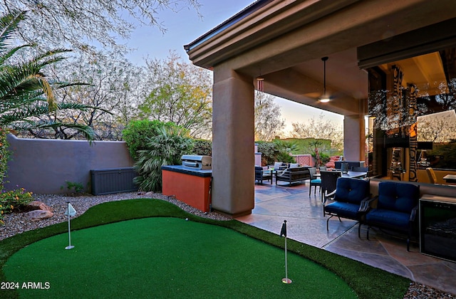 yard at dusk featuring area for grilling, a patio, and an outdoor hangout area