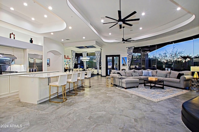 living room featuring a raised ceiling and ceiling fan